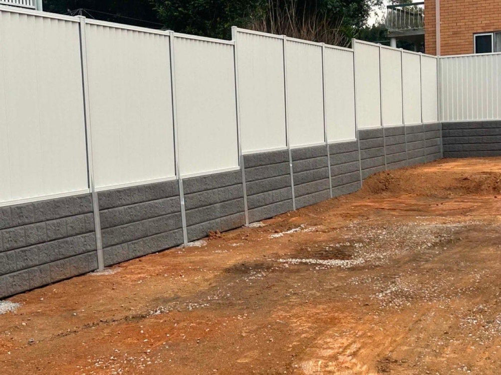 Levelled site in front of a long concrete block retaining wall