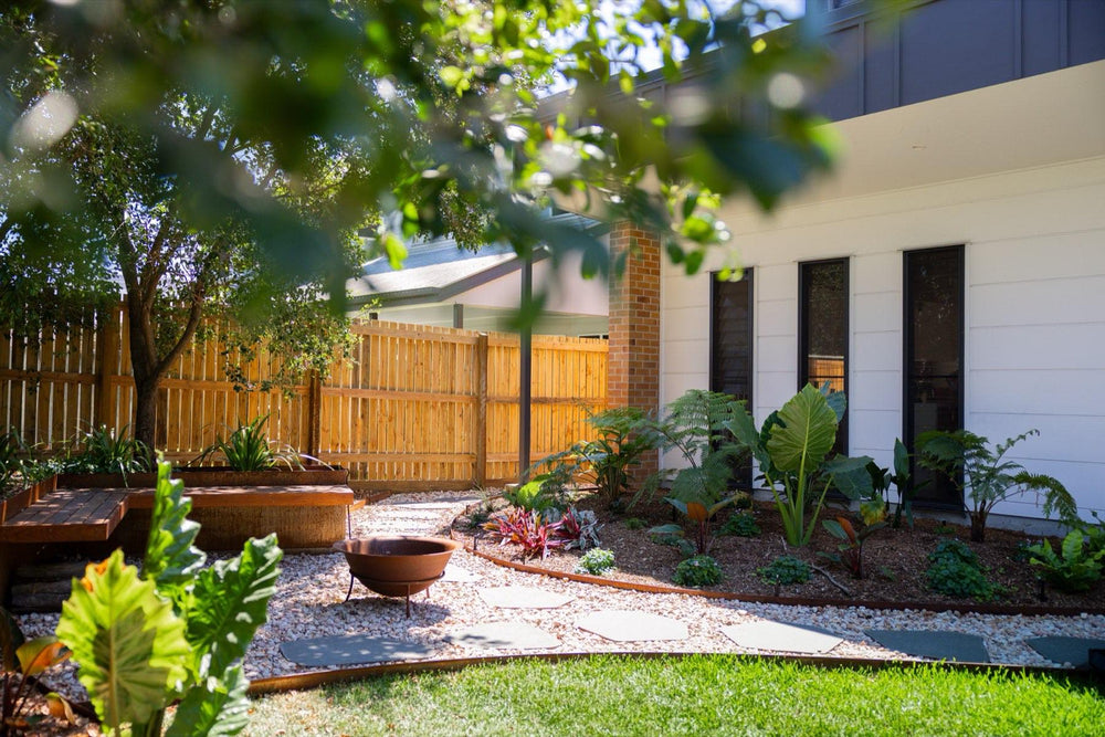 Finished backyard landscaping in Brisbane's Bayside with timber fence, garden beds and gravel path