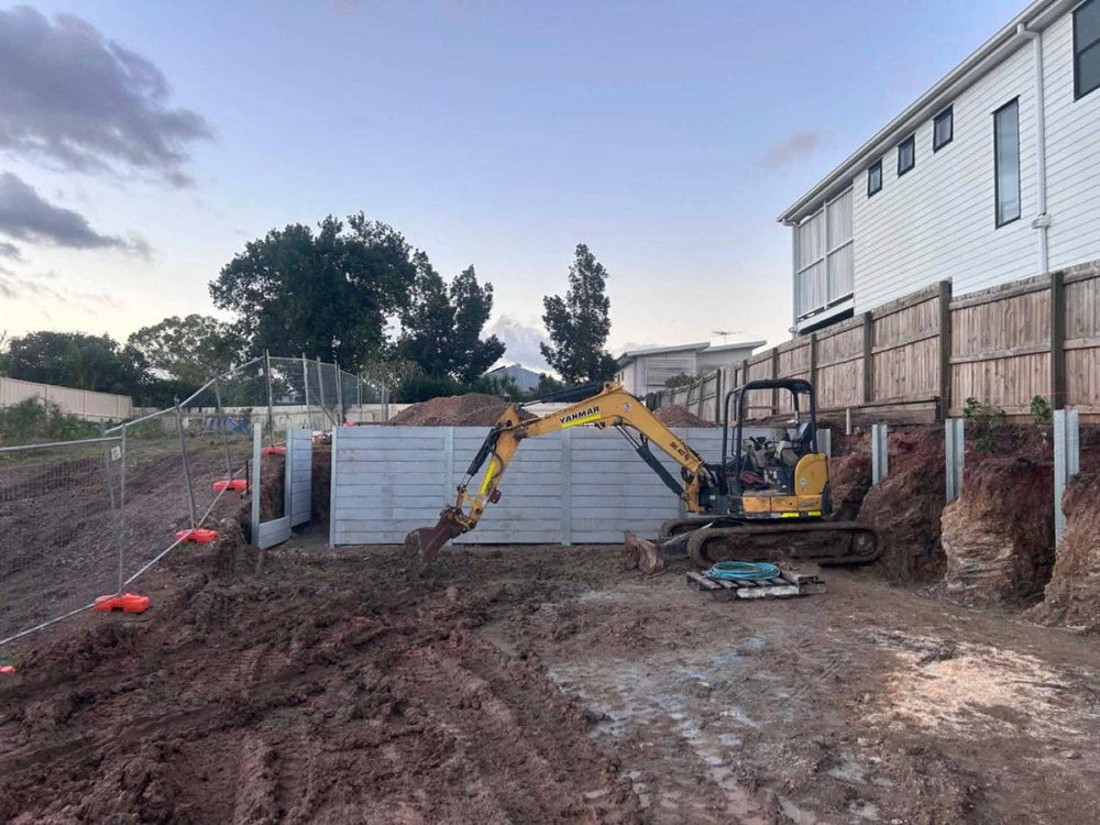 Concrete sleeper retaining wall going in with mini excavator on site
