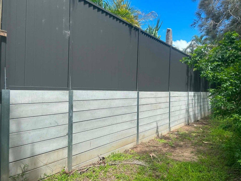 Concrete sleeper boundary wall with dark Colorbond fence