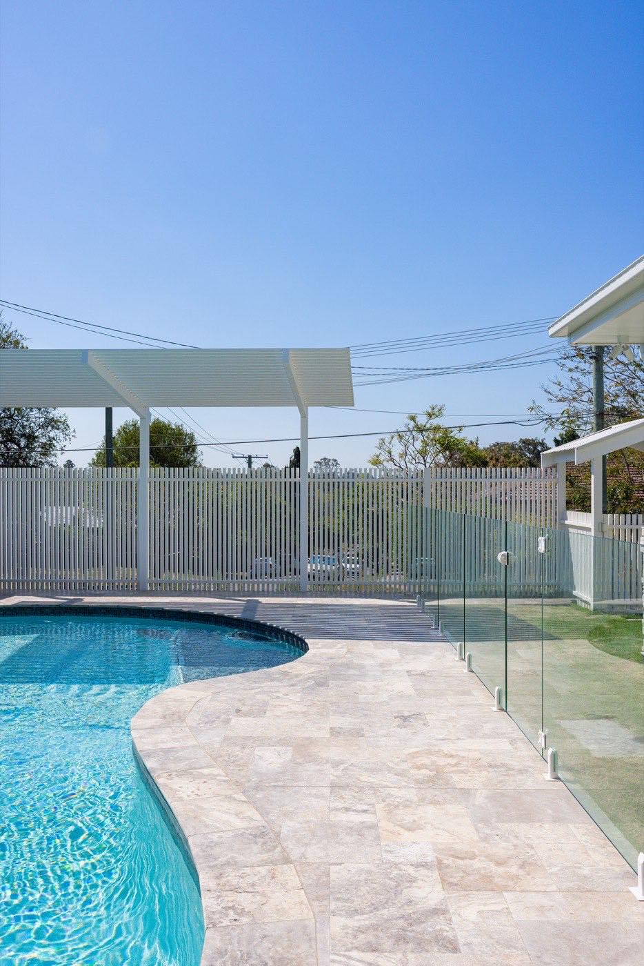 Pool with glass fencing, white slat fence and pergola